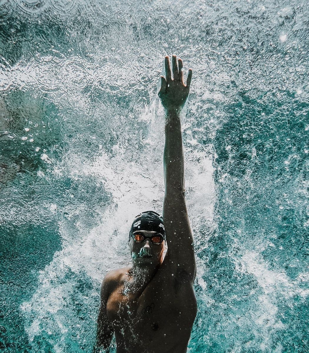 Swimmer performing backstroke in competition pool